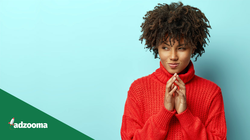Save Download Preview Pensive black young woman strategist has great plan, holds hands together, looks curiously with intention to do something aside, has great plan, wears red clothes, isolated over blue background